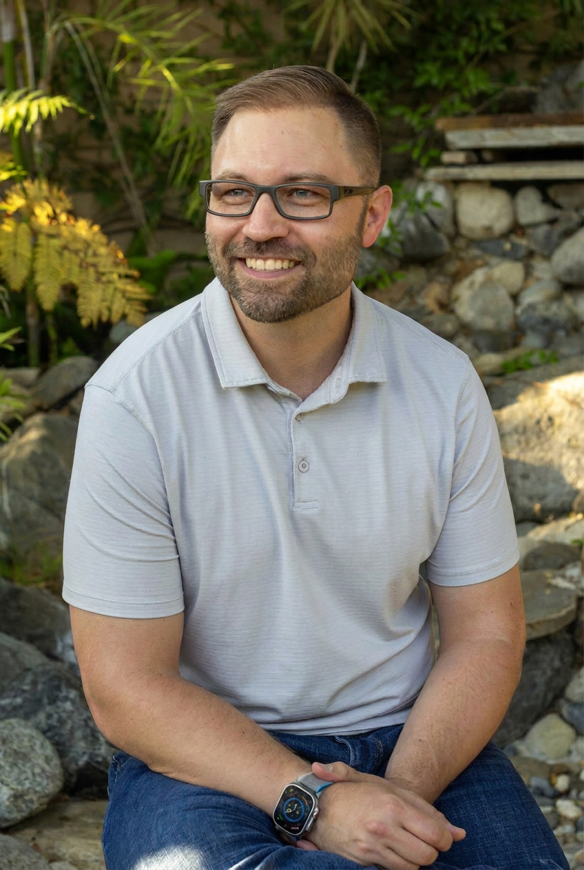 Luke Angus, ADHD coach, seated outdoors.